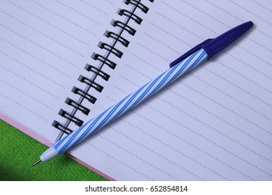 The pen is placed on a blank note.
