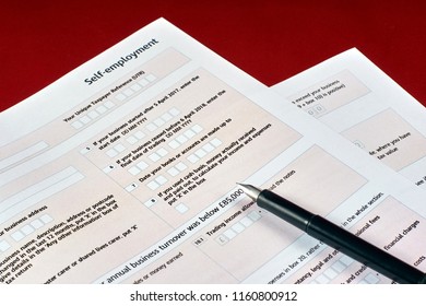 Pen And Self Employment Tax Form On Red Velvet Background