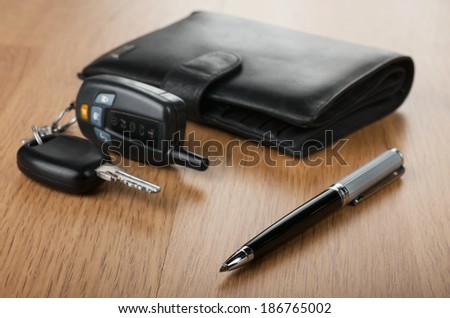 Pen wallet and car keys lay on parquet, can be used as background
