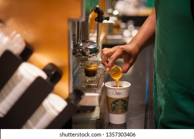 Penang, Malaysia - 02 April, 2019 - Close up of a Starbucks Coffee Barista is standing in front coffee machine and making an americano coffee for customers. at a Starbuck Cafe outlet in Penang.