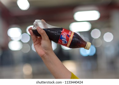 Penang , MALAYSIA 13th July, 2018: A hand holding a bottle of coke with bokeh light background . Coca Cola is American beverage company was founded in 1886 . - Shutterstock ID 1133440424