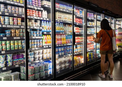 PENANG, MALAYSIA - 14 DEC 2021: Interior view of huge refrigerator shelves with various frozen food and dairy products in a grocery store, Penang. Soft focus image.