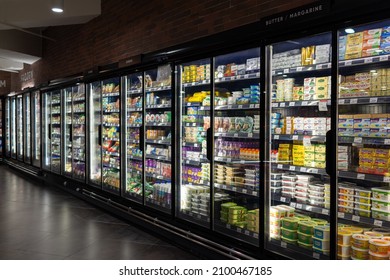 PENANG, MALAYSIA - 14 DEC 2021: Interior view of huge refrigerator shelves with various frozen food and dairy products in a grocery store, Penang. Soft focus image.