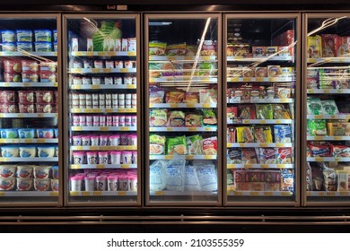 PENANG, MALAYSIA - 2 JAN 2022: Interior view of huge refrigerator shelves with various frozen food and dairy products in a grocery store, Penang.