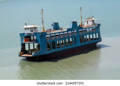 PENANG, MALAYSIA - 26 MAR 2022: Vintage blue Penang ferry abandoned at the sea shore. The Penang Ferry is an iconic way to travel between George Town and Butterworth.