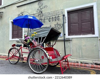 Penang, Malaysia - 5 April 2022: Old Red Trishaw, Three Wheels Vintage Stop Beside Street In George Town, Penang Town Area. Soft Focus