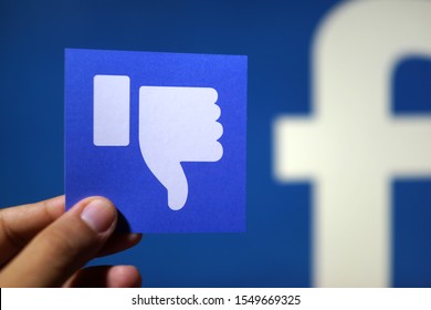 PENANG, MALAYSIA - APRIL 25, 2018: Facebook Security And Privacy Issues. Close Up Hand Holding A Dislike Icons With Facebook Logo As Background.