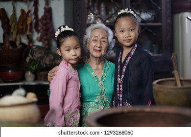 Penang, Malaysia - January, 22 2019: A Beautiful Old Woman Model Posing With Two Young Girls. Chinese Traditional Clothing And House Can Be Found In Peranakan Mansion In Penang.