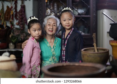 Penang, Malaysia - January, 22 2019: A Beautiful Old Woman Model Posing With Two Young Girls. Chinese Traditional Clothing And House Can Be Found In Peranakan Mansion In Penang.