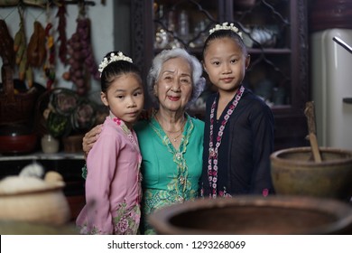 Penang, Malaysia - January, 22 2019: A Beautiful Old Woman Model Posing With Two Young Girls. Chinese Traditional Clothing And House Can Be Found In Peranakan Mansion In Penang.