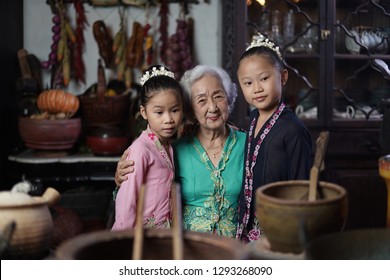 Penang, Malaysia - January, 22 2019: A Beautiful Old Woman Model Posing With Two Young Girls. Chinese Traditional Clothing And House Can Be Found In Peranakan Mansion In Penang.