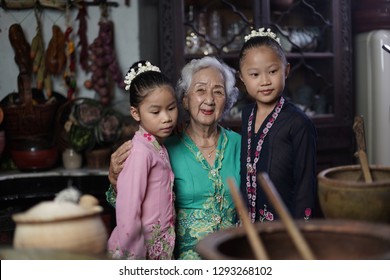 Penang, Malaysia - January, 22 2019: A Beautiful Old Woman Model Posing With Two Young Girls. Chinese Traditional Clothing And House Can Be Found In Peranakan Mansion In Penang.