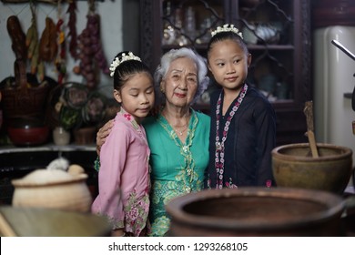 Penang, Malaysia - January, 22 2019: A Beautiful Old Woman Model Posing With Two Young Girls. Chinese Traditional Clothing And House Can Be Found In Peranakan Mansion In Penang.