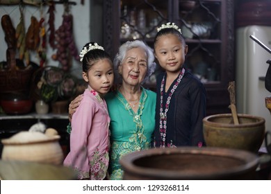 Penang, Malaysia - January, 22 2019: A Beautiful Old Woman Model Posing With Two Young Girls. Chinese Traditional Clothing And House Can Be Found In Peranakan Mansion In Penang.