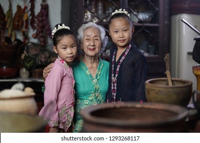 Penang, Malaysia - January, 22 2019: A Beautiful Old Woman Model Posing With Two Young Girls. Chinese Traditional Clothing And House Can Be Found In Peranakan Mansion In Penang.