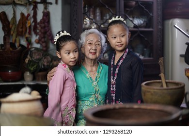 Penang, Malaysia - January, 22 2019: A Beautiful Old Woman Model Posing With Two Young Girls. Chinese Traditional Clothing And House Can Be Found In Peranakan Mansion In Penang.