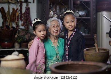 Penang, Malaysia - January, 22 2019: A Beautiful Old Woman Model Posing With Two Young Girls. Chinese Traditional Clothing And House Can Be Found In Peranakan Mansion In Penang.