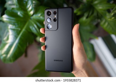 PENANG, MALAYSIA - MAR 11, 2021: Hand holing the latest Samsung Galaxy S21 Ultra 5G Phantom Black color and showing the back of the phone and brand new camera lens in green leaf background