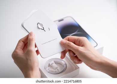 PENANG, MALAYSIA - OCT 10, 2022: Apple IPhone 14 Pro Max Unbox In Isolated White Background. Hand Holding IPhone Booklet And Showing SIM-eject Tool.