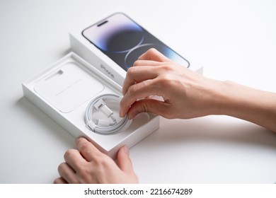 PENANG, MALAYSIA - OCT 10, 2022: Apple IPhone 14 Pro Max Unbox In Isolated White Background. Hand Holding IPhone Lighting Cable During Unbox