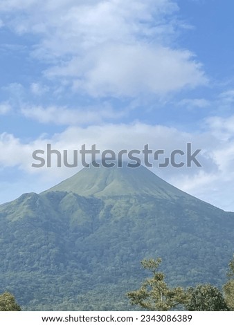 Penanggungan mountain or a mountain at East Java from a far in a sunny day. A mountain with cloud on top