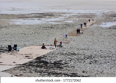 Penarth, Cardiff, Wales - July 5 2020: The Last Day Of Stay Local Rule In Wales And People Enjoy The Beach Remembering To Stay Socially Distanced And 2 Metres From Each Other Walking Down The Slipway