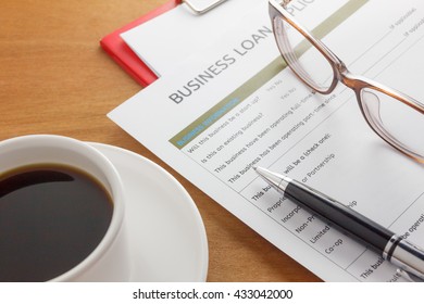 pen,Business loan application form,coffee,glasses,paper clip on wood business background. - Shutterstock ID 433042000