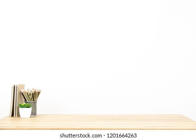 pencil, book, model and some office stuff and decoration on the clean and clear wooden table. White background and more copy space. Business or Work space theme