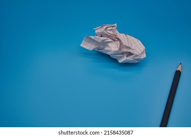 A pencil   crumpled piece paper isolated blue background and copy space