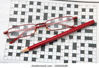 Pencil And Glasses On The Newspaper With A Crossword.