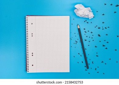 A pencil  notebook   crumpled piece paper isolated blue background and copy space
