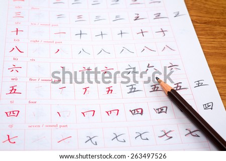 Pencil and notebook for learning Chinese hieroglyphs.