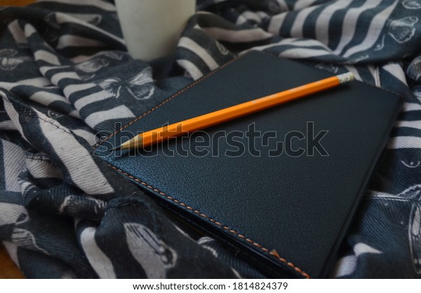 Pencil and\
notepad for notes. Diary. Cup of\
coffee.