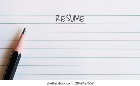 Pencil on note paper with text written RESUME, concept of job applicant write a summing up for job application or make money being professional resume writer for job seeker