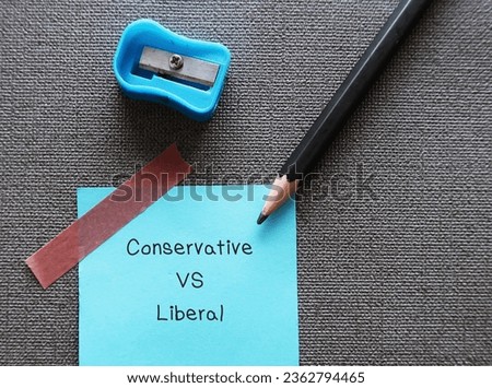 Pencil on note paper with text handwritten CONSERVATIVE VS LIBERAL, concept of people on different ends of political spectrum