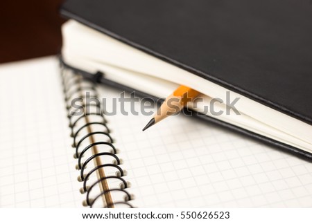 Pencil on the pages of an closed notebook