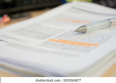 Pencil placed on scientific journal paper with highlight color  