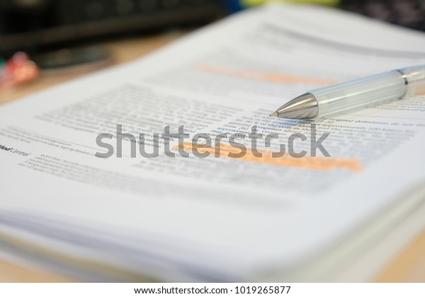 Pencil placed on scientific journal paper with highlight\
color  
