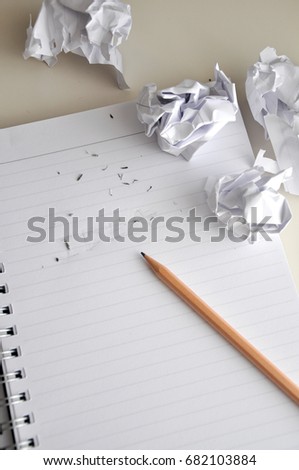 Pencil point to erase words idea on paper with crumpled paper throw around