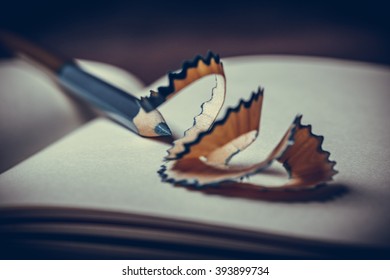 A pencil sharpener , blank notebook with pencil on wooden table - still life