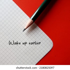 Pencil Writing A Goal On White Paper With Handwritten Text Wake Up Earlier, To Improve Overall Wellness, Enhances Productivity,decrease Stress Level From Being Rush To Work