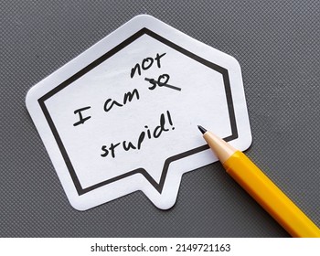 Pencil writing on words sticker with handwrtten text I AM NOT STUPID, changed to I AM NOT STUPID, to overcome negative self talk and raise self esteem
