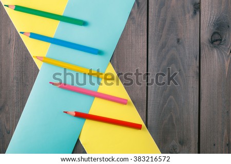 penciles with crosser color band on rustic wooden table