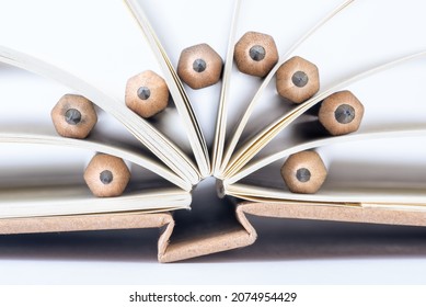 Pencils as Bookmarks Between the Sheets of Notebook Close-up