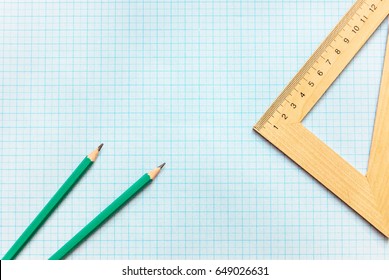 Pencils with ruller on the graph paper. Top View.