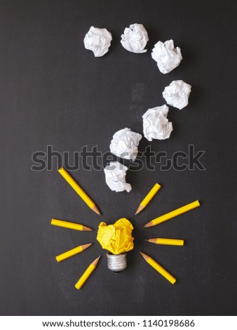 Question mark, paper balls, light bulb with pens