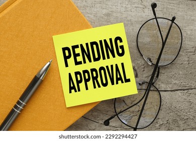 pending approval words on a small sheet of paper placed on a yellow notepad - Shutterstock ID 2292294427