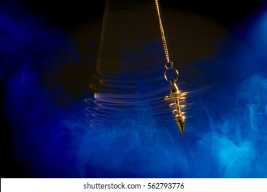 Pendulum used for hypnotism and readings swinging with motion blur