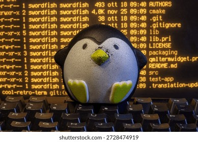 Penguin mascot coding on computer keyboard displaying source code in terminal window