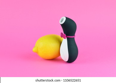 Penguin sex toy for adult, design minimal dildo vibrator for clitoris isolated on pink background. Food concept with yellow lemon